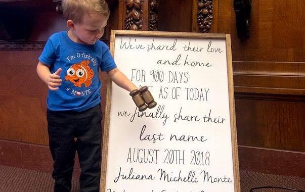 Four year old boy holds gavel to celebrate his adoption by his foster parents.