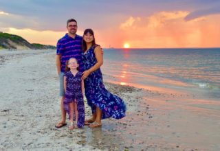 Mentor foster parents with adopted young daughter on beautiful beach at sunset!